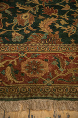 A close view of the turtle samovar border, floral green field, and hand-knotted fringe.