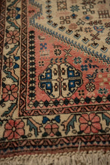 Corner of a vintage Abadeh rug showing its plush pile, floral border, and geometric patterns.