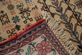 Full pile, intact red side cord, and knotted fringe on the corner of a vintage Persian rug.