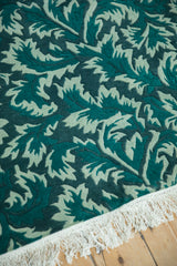 Shallow carved contour of the pile highlights serrated leaves in jade and teal green.