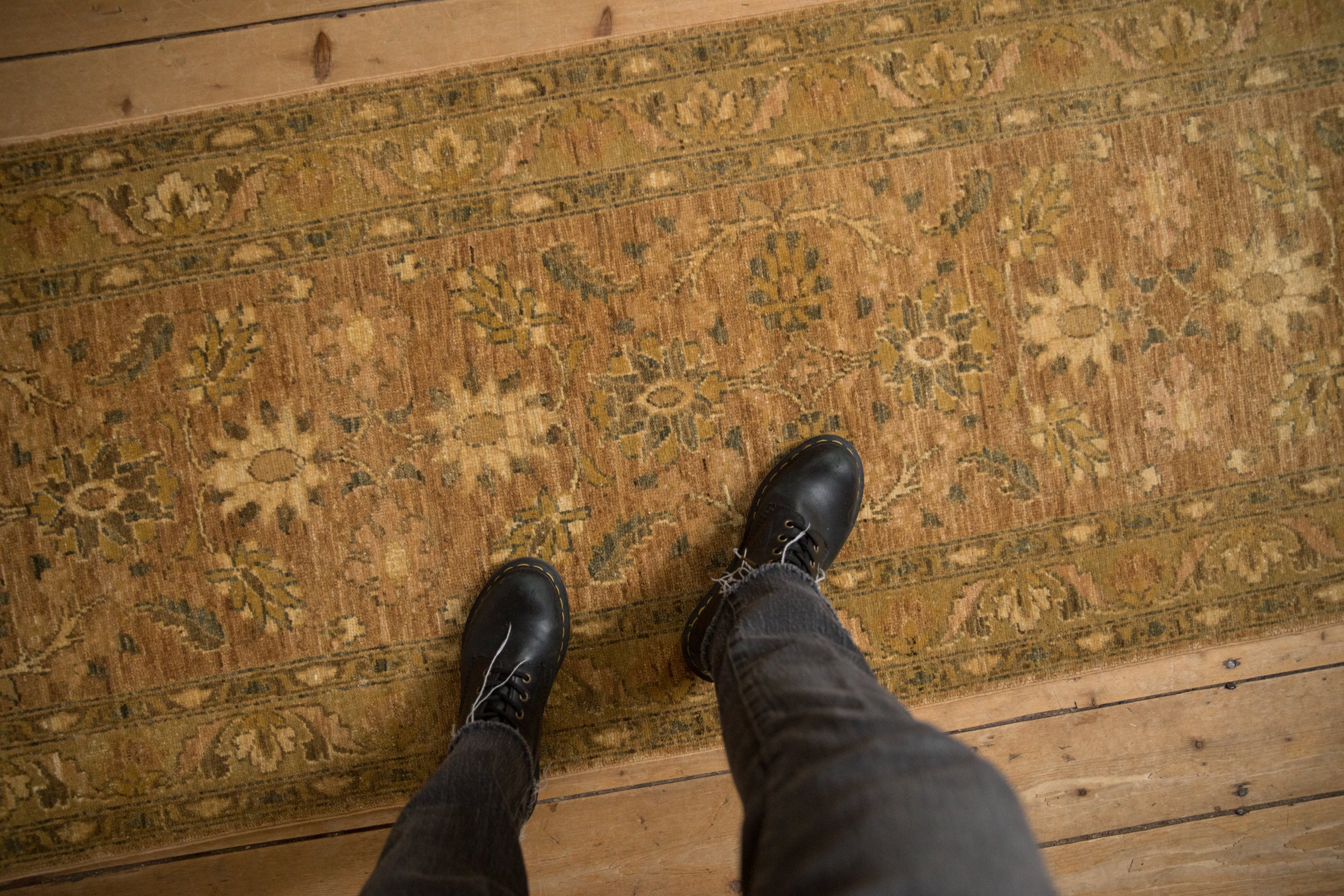 The even, short pile and detailed floral pattern of a Peshawar runner viewed from above.