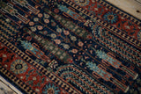 Pakistani Bakhtiari rug runner's navy field with weeping willow motifs and red floral border.