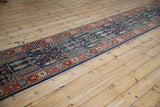 Brick red floral border, palmette motifs, and dusty navy field of vintage runner.