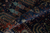 Rolled Pakistani Bakhtiari runner showing its short pile and dusty navy, brick red palmette motifs.