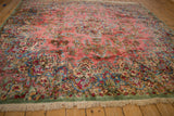 Vintage Kerman rug showing celadon green border, intricate floral sprays, and ivory fringe.