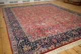 Close-up of vintage Agra rug showing navy border's Islimis and red field's arabesque motifs.
