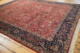Agra carpet's navy blue border with intricate Islimis, scrolling vinery, and ivory fringe.