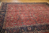 Agra carpet corner with brick red arabesque field and navy scrolling vinery border.