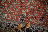 Even pile of the vintage carpet's red floral field and meandering navy vine border.