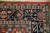 Detail of the meandering vine border and gul ferang motifs on a vintage Bijar design carpet.
