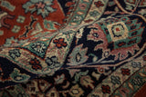 Dense hand-knotted pile showing navy, dusty rose, and jade green floral details.
