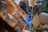 Intricate cochineal red and sapphire blue pattern on aged Kerman rug fragment.