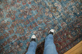 Vintage Mahal carpet's worn aqua blue field with repeating burgundy and green floral patterns.