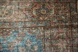 Mahal carpet corner detail: aqua blue field, intricate floral patterns, and softened red border tones.