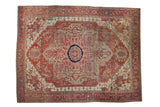 Antique Serapi carpet with an oversized starburst medallion in terracotta, navy blue, and ivory on a floral field.