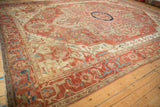 Expansive angled view of an antique Serapi carpet showing its terracotta medallion and Samovar border.