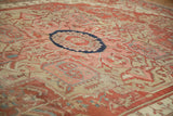 Low angle perspective on the hand-knotted pile and geometric patterns of an antique Serapi carpet.