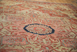 Angled perspective on the quatrefoil starburst medallion of an antique Serapi carpet.