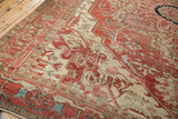 Angled view of an antique Serapi carpet highlighting its serrated patterns and time-softened patina.