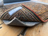 Thicker Cushion Rug Pad showing gray felted top and dark rubber waffle backing.