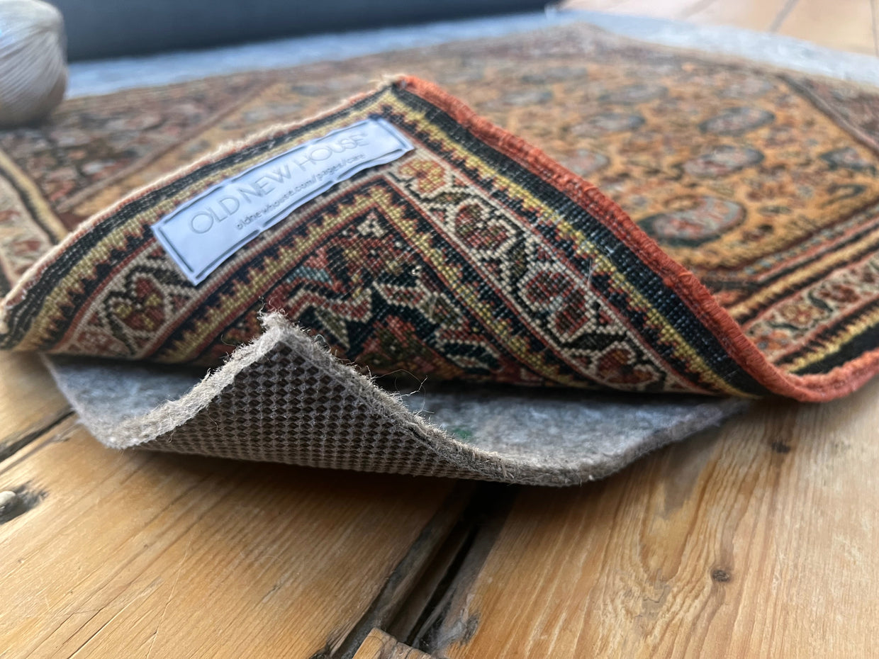 Thicker Cushion Rug Pad showing gray felted top and dark rubber waffle backing.