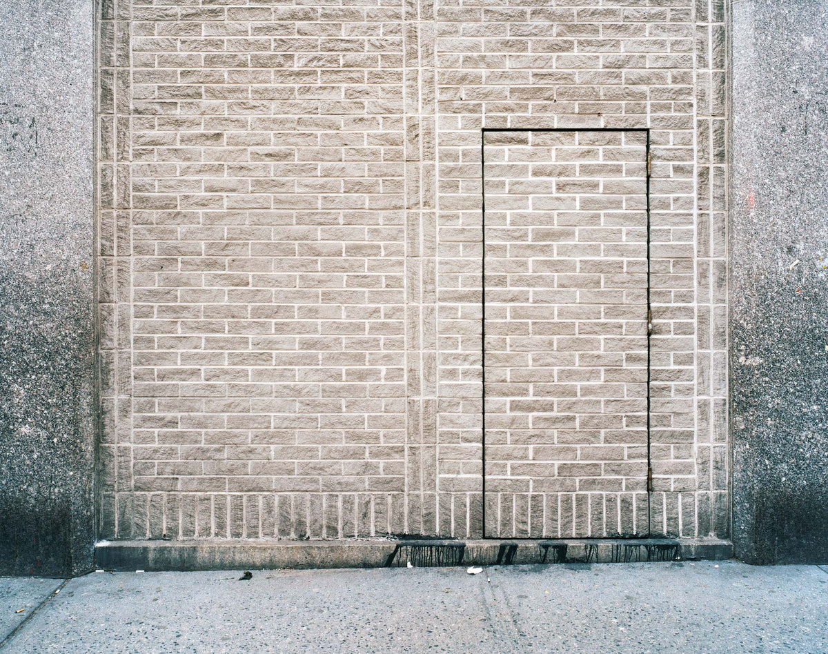 Joe Farrell's Avenue A color photograph of a brick wall with a minimalist doorway outline.