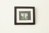 Sleek black wall art frame with a vintage finish holding a matted photo.