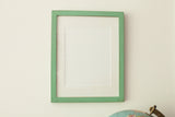 Sleek mint green wall art frame with a vintage-style finish and white mat.