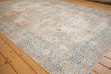 Decorative worn texture of a vintage Sparta carpet with teal arabesque border.