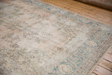 Distressed vintage Sparta carpet showing faded rose pile, foundation, and teal border.