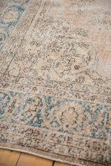 Distressed vintage Sparta rug texture with faded dusty rose, ivory, and teal design.