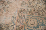 Distressed Turkish Sparta rug with dusty rose and teal border, visible foundation wear.