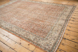 Distressed Sparta carpet corner, showing pale terracotta field and ivory border with delicate vinery.
