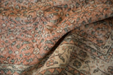Faded peach, ivory, and muted green vinery pattern on distressed vintage Sparta carpet showing wear.