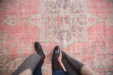 Distressed vintage Turkish Sparta rug, muted pink starburst medallion with geometric pearl overlay.