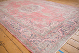Distressed pink and charcoal vintage Sparta carpet corner, featuring scrolling serrated leaves border.