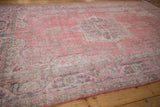 Distressed pink vintage Sparta carpet pile, showing wear to foundation and faded border details.