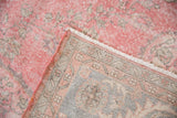 Distressed vintage Sparta carpet showing worn pile, white fringe, and hand-knotted foundation.