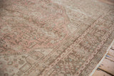 Distressed vintage Isparta rug pile with faded dusty rose, green, and brown geometric floral vinery.