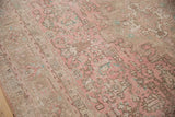 Faded dusty rose and coffee brown geometric vinery of a distressed vintage Isparta carpet.