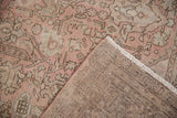 Distressed Isparta carpet showing mostly even wear on dusty rose and seafoam geometric motifs with turned back.