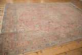 Distressed vintage Isparta rug corner showing pale coffee border, aqua blue motifs, intact selvage.