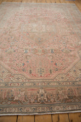 Distressed Isparta rug border detail, featuring vinery and blossoms in soft dusty rose, beige, and blue.