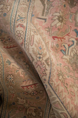 Distressed texture of vintage Isparta carpet, showing dusty rose, pale coffee, and denim aqua.