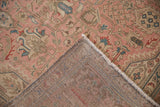 Distressed dusty rose pile and visible hand-knotted backing of an Isparta rug.