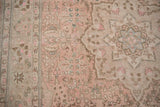 Distressed Isparta carpet, faded floral patterns in dusty rose, beige, and seafoam tones.