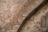Distressed vintage Isparta carpet with decorative worn texture and pale floral motifs.
