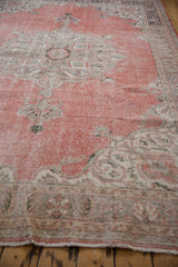 Distressed vintage Sparta carpet's worn border and fine fringe in dusty rose and beige.