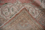 Distressed Sparta carpet corner showing worn dusty blush pile, fringe, and woven back.
