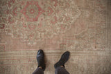 Distressed vintage Oushak rug's worn pile and muted dusty pink, beige pattern seen underfoot.